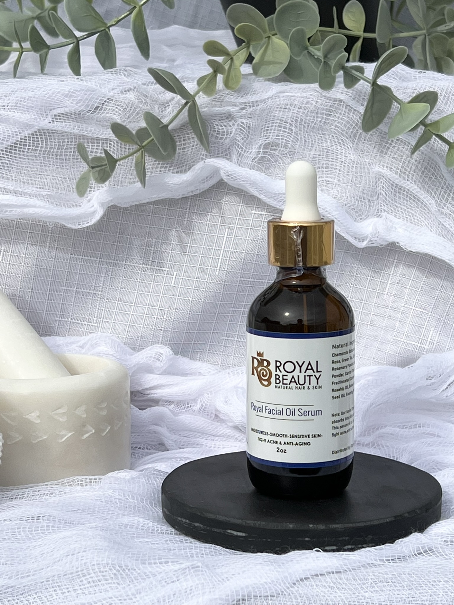 Royal Facial Oil Serum on black disc with plant in background